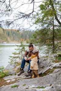 Photo by Tatiana Syrikova on Pexels.com Image of an adult with a toddler in the woods by a lake